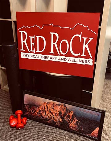 The interior of Red Rock Physical Therapy in McHenry, showing our sign next to our fireplace